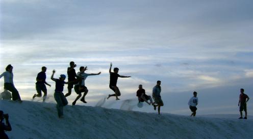 Undergrad students jumping of a gypsum sand dune in New Mexico